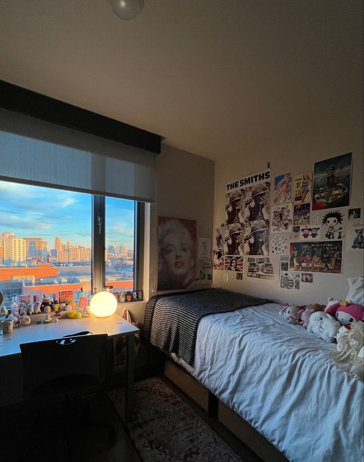 a bed room with a neatly made bed next to a large window and a painting on the wall