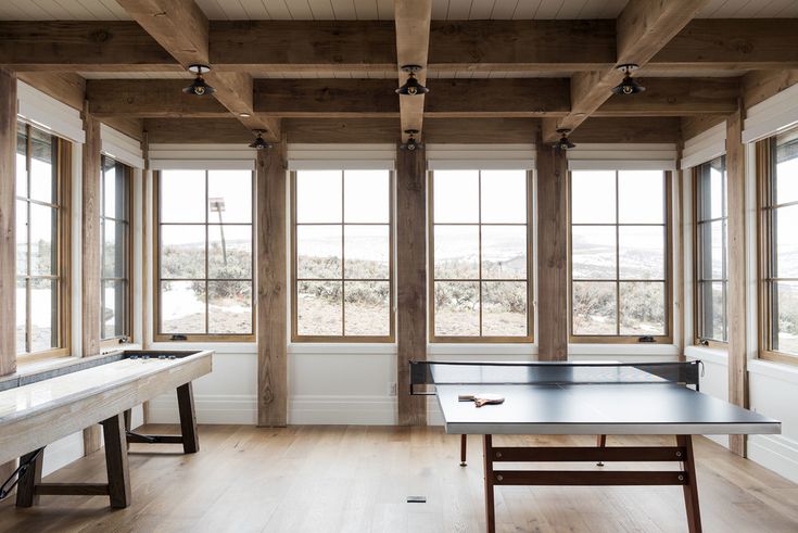 an empty room with ping pong tables and windows