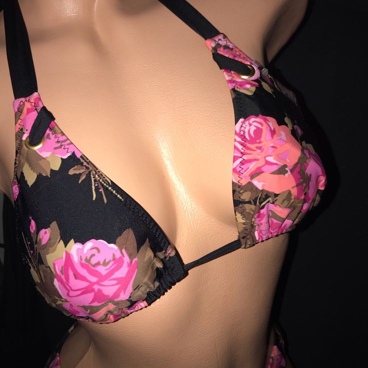 a close up of a woman's bra with pink flowers on it and black straps