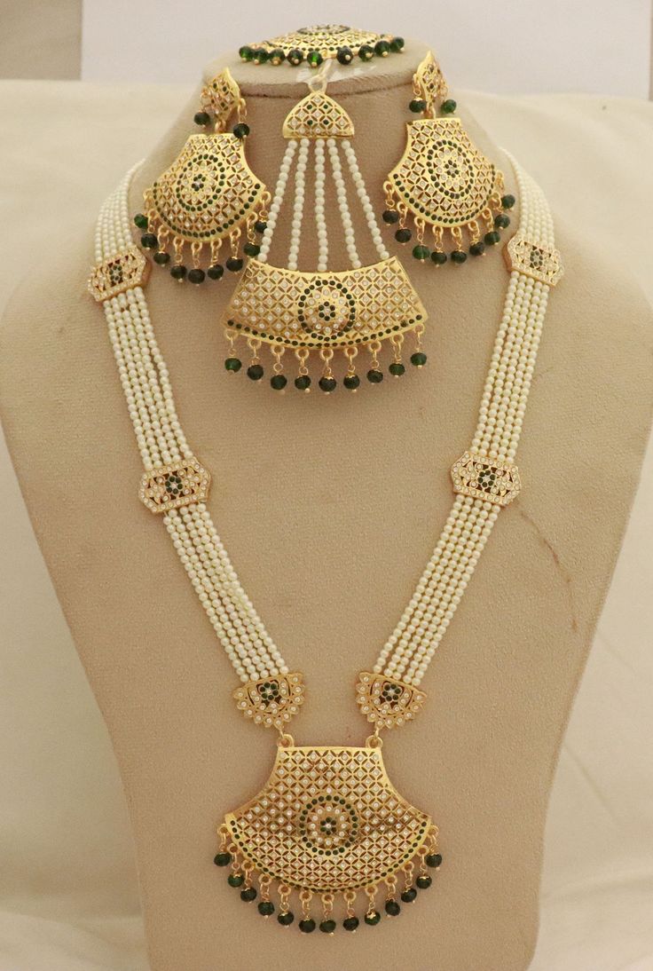 Ranihaar Bridal Necklace Earrings Tika Jhoomar Jewelry Set, Green Beads Long Necklace Earrings Tikka Jhoomar, Engagement Passa Jewelry Set Metal        = Gold Plated Occasion  = Wedding ,Party Wear, Bridal Color        =  Gold and Green Size          = Necklace Length = 40 CM Earrings/Studs = 9 CM  Tika = 12 CM Jhoomar =  8 CM 100% Satisfaction Guarantee: 1 Year Warranty, Long Lasting Plating, High-Quality Stones Occasion: Perfect choice for any Indian occasion.  Happy Buying :) White Jewelry With Latkans For Eid, White Latkans Jewelry For Eid, White Chandbali Jewelry For Navratri, White Jewelry For Navratri Ceremonial, White Ceremonial Jewelry For Navratri, Heavy White Jewelry For Navratri, White Temple Jewelry Chandbalis For Eid, White Stone Work Danglers For Festivals, White Temple Jewelry Danglers With Stone Work