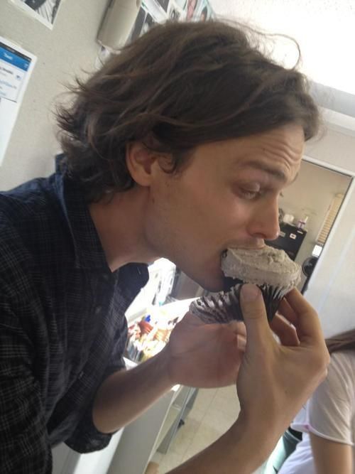 a man is eating a chocolate cupcake