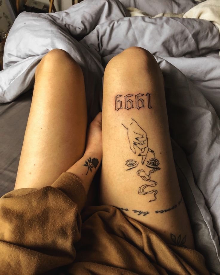 a person with tattoos on their legs laying in bed