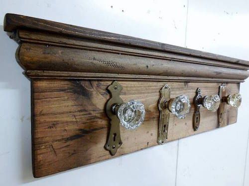 a wooden coat rack with four knobs on the front and two hooks on the back