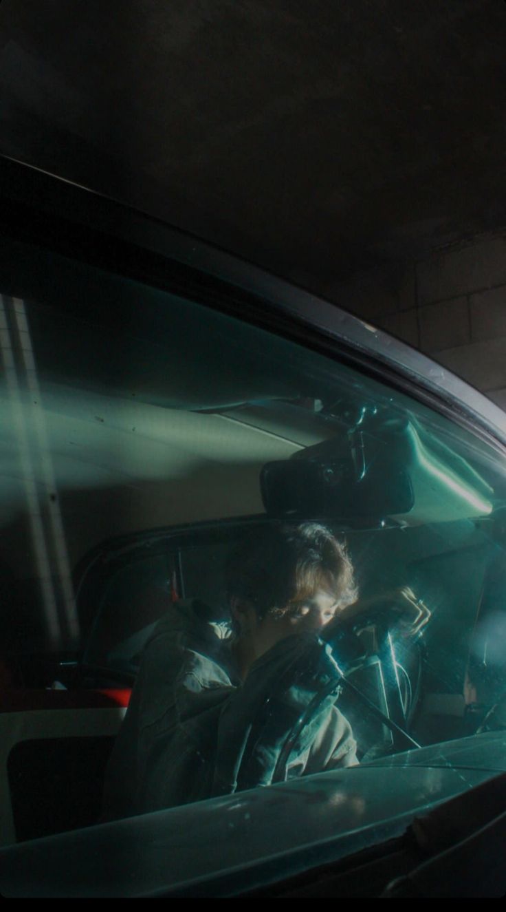 two people sitting in a car looking out the window