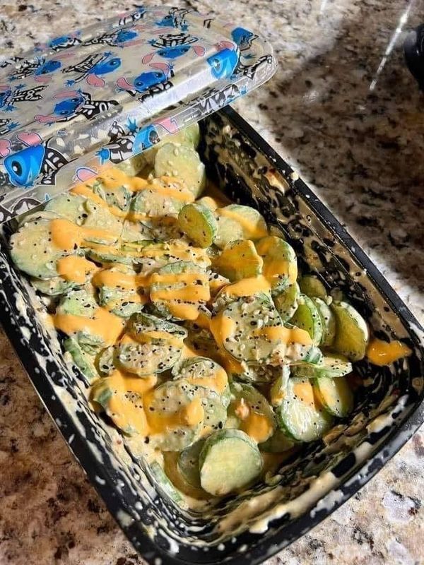 a casserole dish with cheese and vegetables in it sitting on a counter top