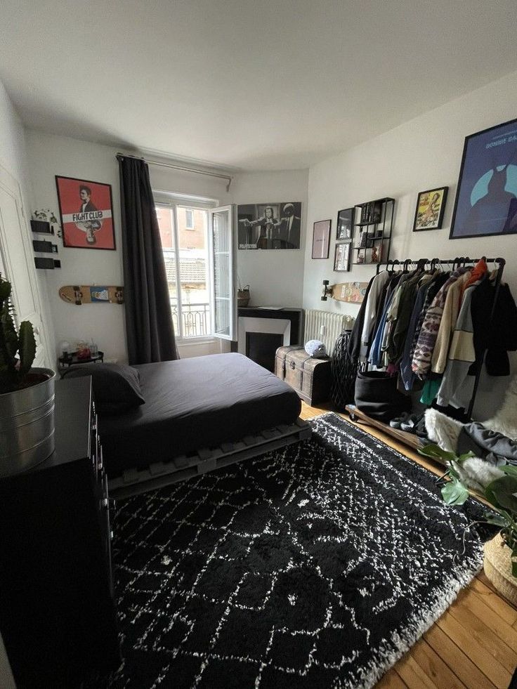 a room with a bed, rug and pictures on the wall above it in front of a window