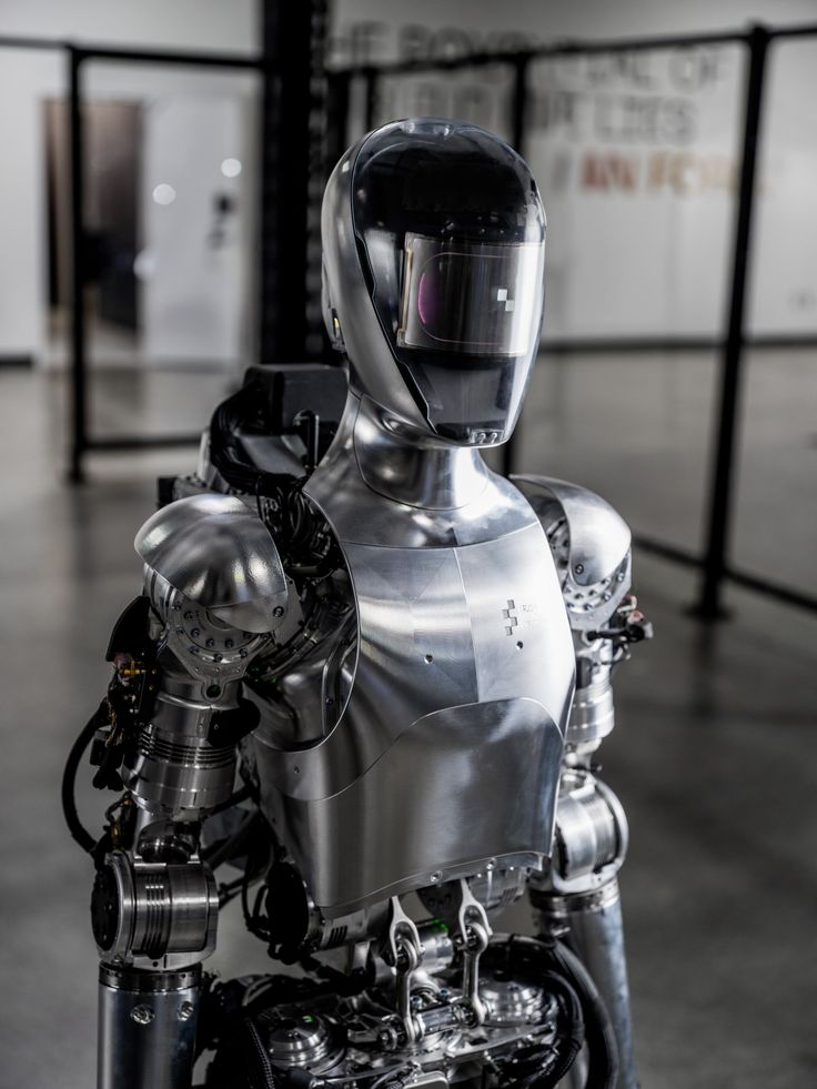 a silver robot is standing in the middle of a room with no one around it