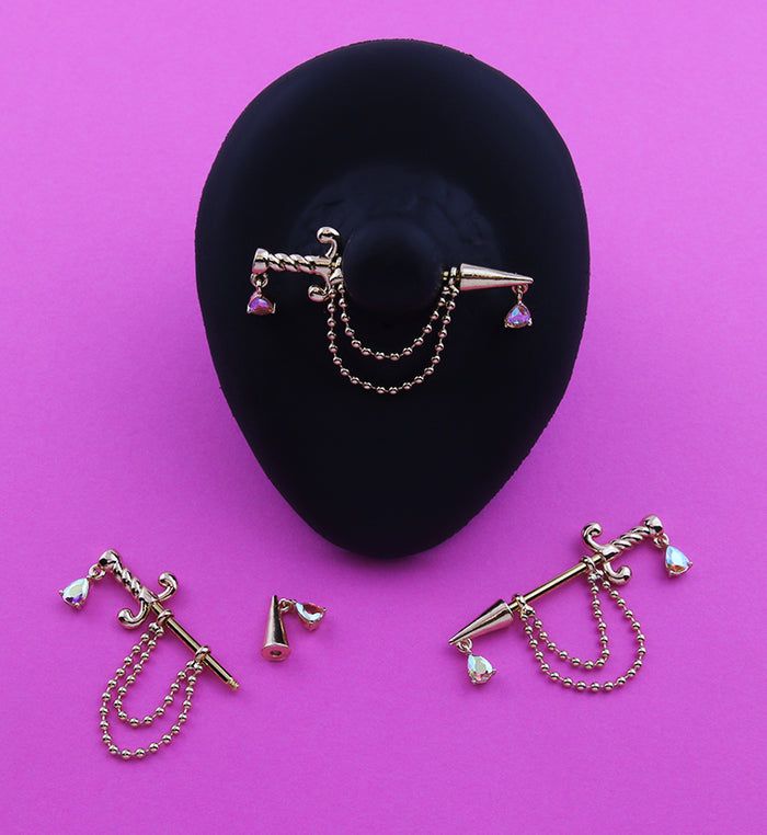 three pieces of jewelry sitting on top of a black hat next to a pair of earrings