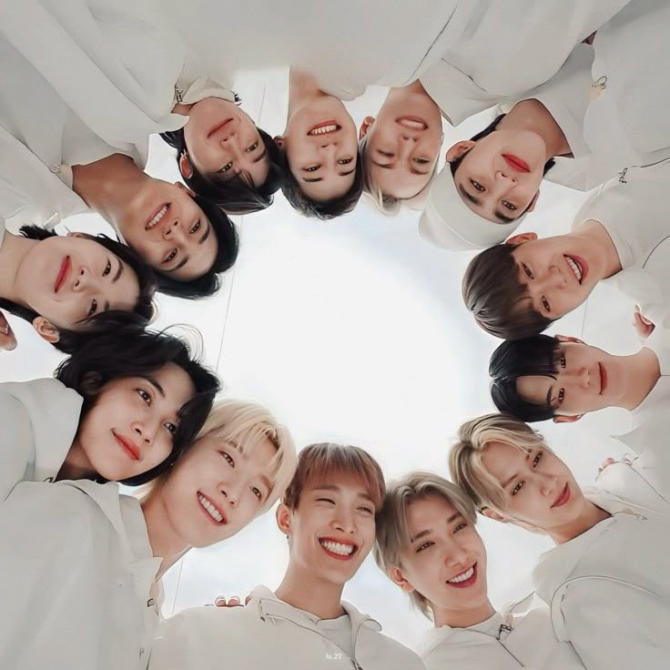 a group of young people standing in a circle looking up at the camera with smiles on their faces