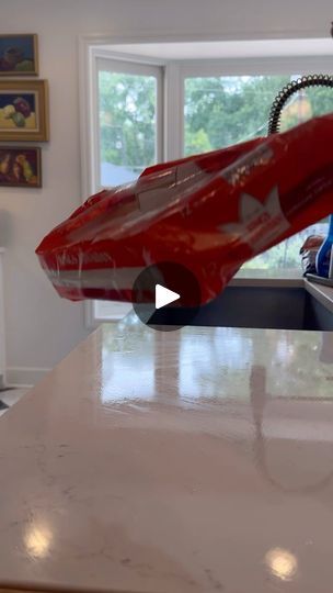 a red toy car sitting on top of a kitchen counter