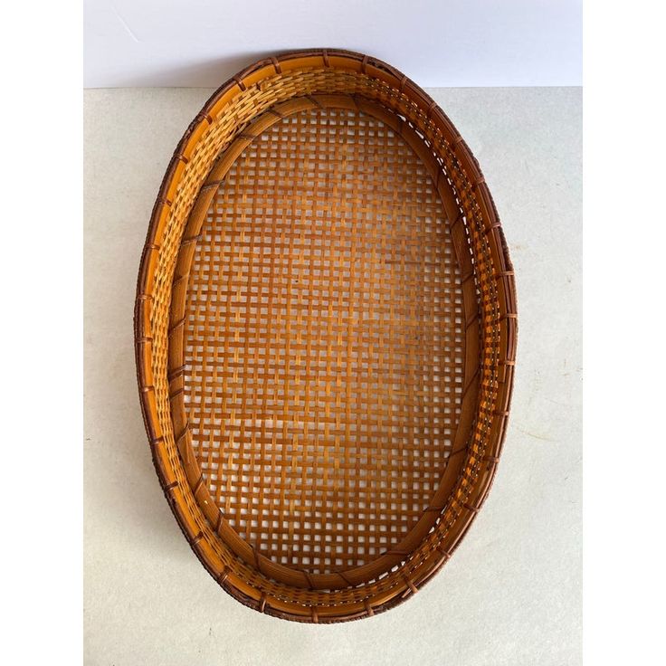 a round bamboo tray with holes in the middle on a white tableclothed surface