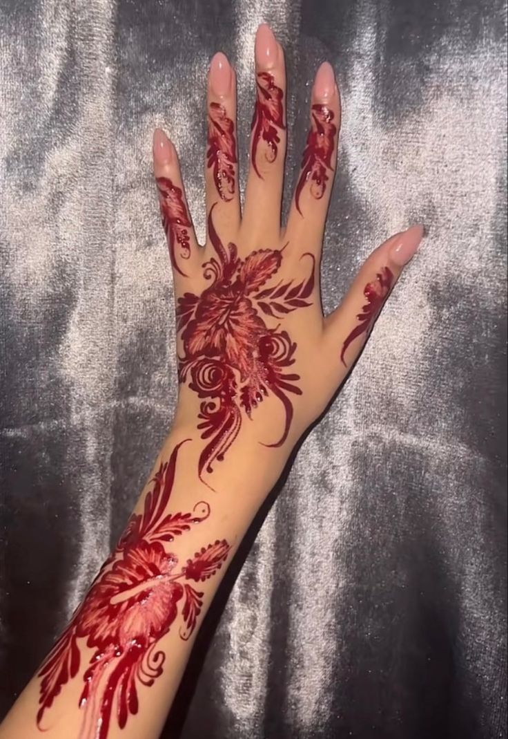 a woman's hand with hendix on it and red flowers painted on the palm