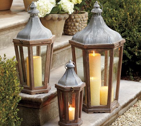 two metal lanterns with lit candles on the steps