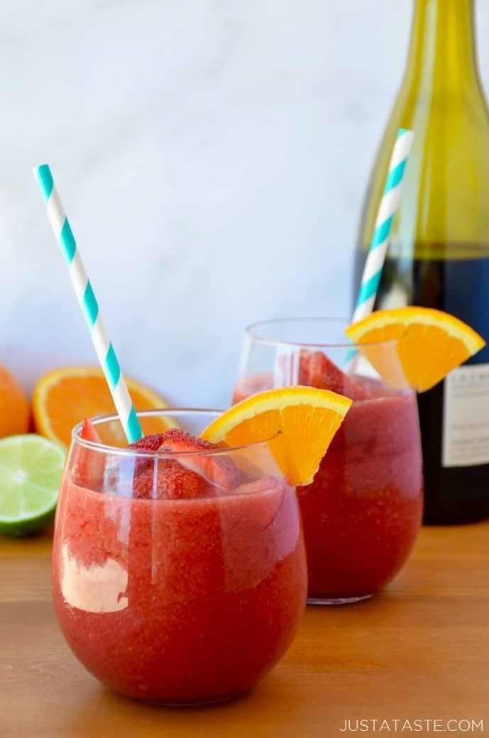 two glasses filled with red liquid and garnished with orange slices