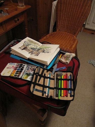 an open book sitting on top of a wooden table next to a chair and desk