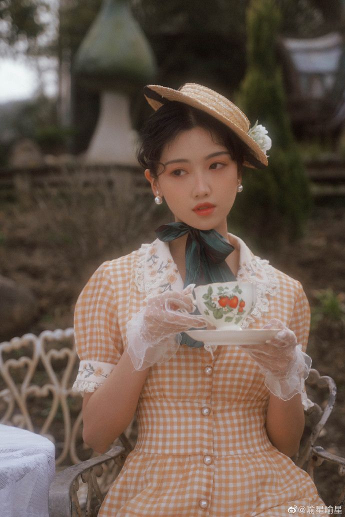 a woman sitting on a bench holding a tea cup and saucer