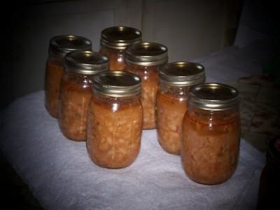 six jars filled with peanut butter sitting on top of a white cloth covered tablecloth