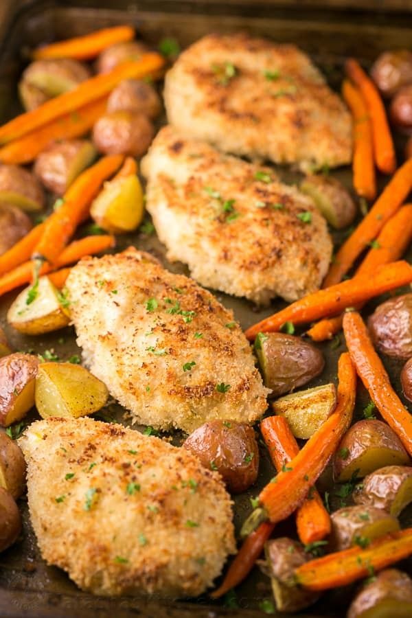 chicken, potatoes and carrots on a baking sheet