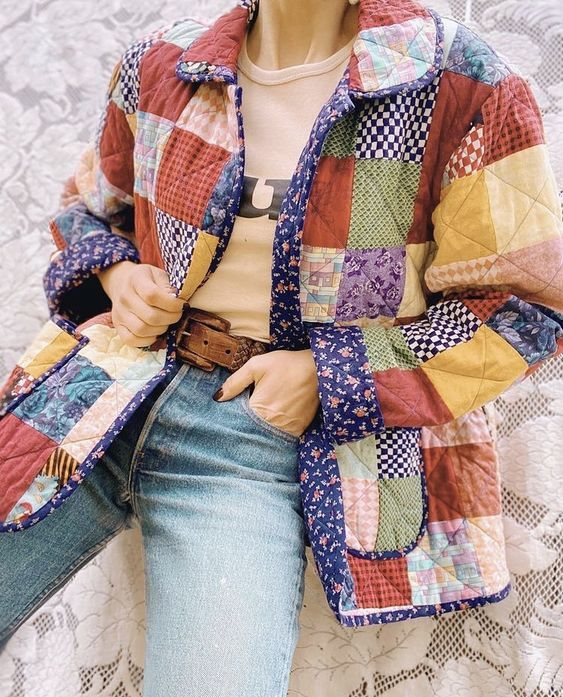 a mannequin wearing a colorful jacket and jeans sitting on a lace tablecloth