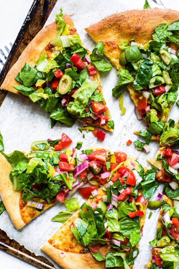 a pizza topped with lots of veggies on top of a pan