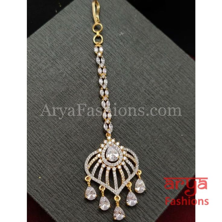 Ruby White Rose Gold CZ Round Mang Tika Mang Tika: Approx. 5 Inches Hook feature to tie the mang tika to hair Made in Brass with very high quality CZ stones Lightweight Jewelry Suitable for any occasion and traditional or Modern attire Ready to ship and available for local pickup from 23059. Please message us for more details Free shipping on orders above $75 within USA. Elegant Adjustable Tikka As Gift, Adjustable Elegant Tikka As Gift, Adjustable Elegant Tikka Gift, Elegant Adjustable Tikka For Festive Occasions, Elegant Adjustable Tikka For Celebration, Adjustable Elegant Tikka For Celebrations, Adjustable Stone Work Tikka For Ceremonial Occasions, Elegant Adjustable Tikka For Diwali, Adjustable Elegant Tikka For Diwali