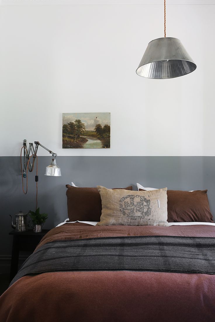 a bedroom with a bed, lamp and pictures on the wall above it is shown