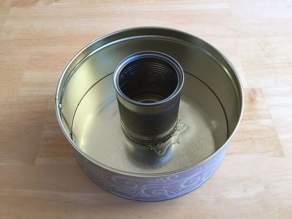 an empty tin can sitting on top of a wooden table