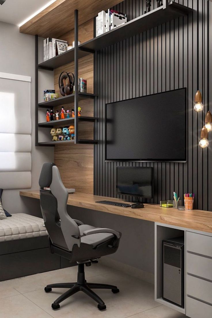 a room with a desk, chair and television on the wall in it's corner