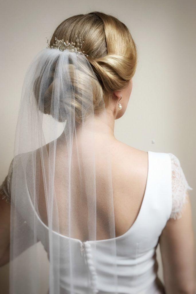 a woman wearing a wedding veil and hair comb