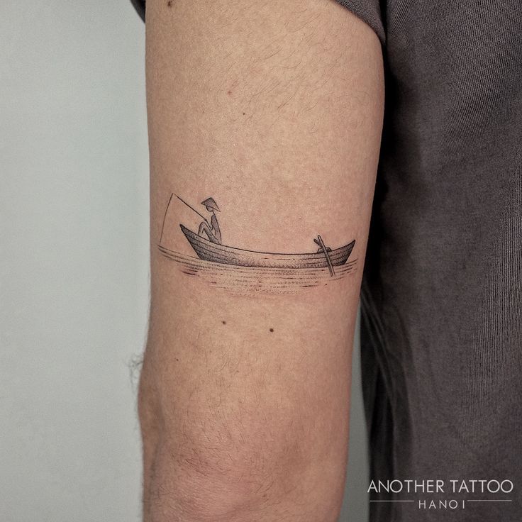 a man with a boat tattoo on his arm