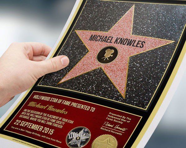 a person holding up a star on the hollywood walk of fame