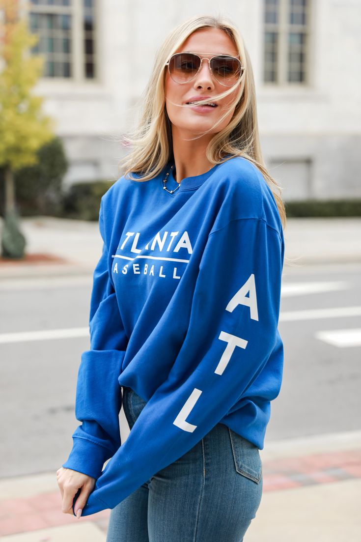 Calling all Braves fans, the Royal Blue Atlanta Baseball Pullover was made just for you! This comfy sweatshirt is designed with a soft and stretchy knit with a fleece interior. It features a crew neckline, long sleeves with "ATL", a relaxed fit, and the words "Atlanta Baseball" on the front. Style the Royal Blue Atlanta Baseball Pullover with your favorite denim and a baseball hat for a game day look! Soft + Stretchy Knit Fabrication Fleece Interior "Blue Atlanta Baseball" Graphic Crew Neckline Blue Crew Sweatshirt For Spring, Blue Crew Neck Spring Sweatshirt, Blue Crew Neck Sweatshirt For Spring, Fan Apparel Long Sleeve Sweatshirt With Ribbed Cuffs, Fan Apparel Long Sleeve Sweater With Ribbed Cuffs, Fan Apparel Sweatshirt With Ribbed Cuffs, Fan Apparel Sweater With Ribbed Cuffs, Blue Sweatshirt With Ribbed Cuffs For Spring, Long Sleeve Sweater With Ribbed Cuffs For Fans