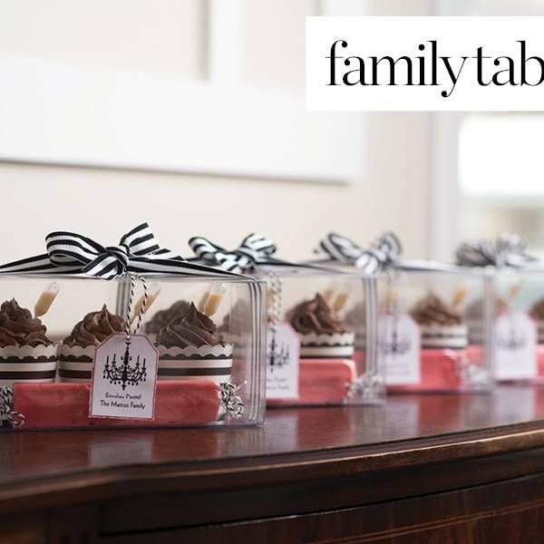 a row of small glass boxes filled with chocolate covered desserts on top of a wooden table