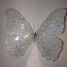 a white butterfly with lots of sparkles on it's wings