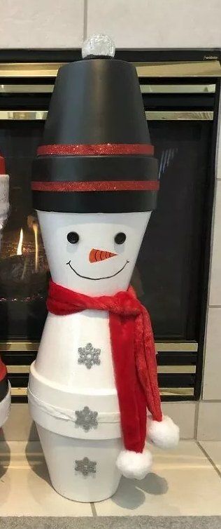 two snowmen standing next to each other in front of a fireplace