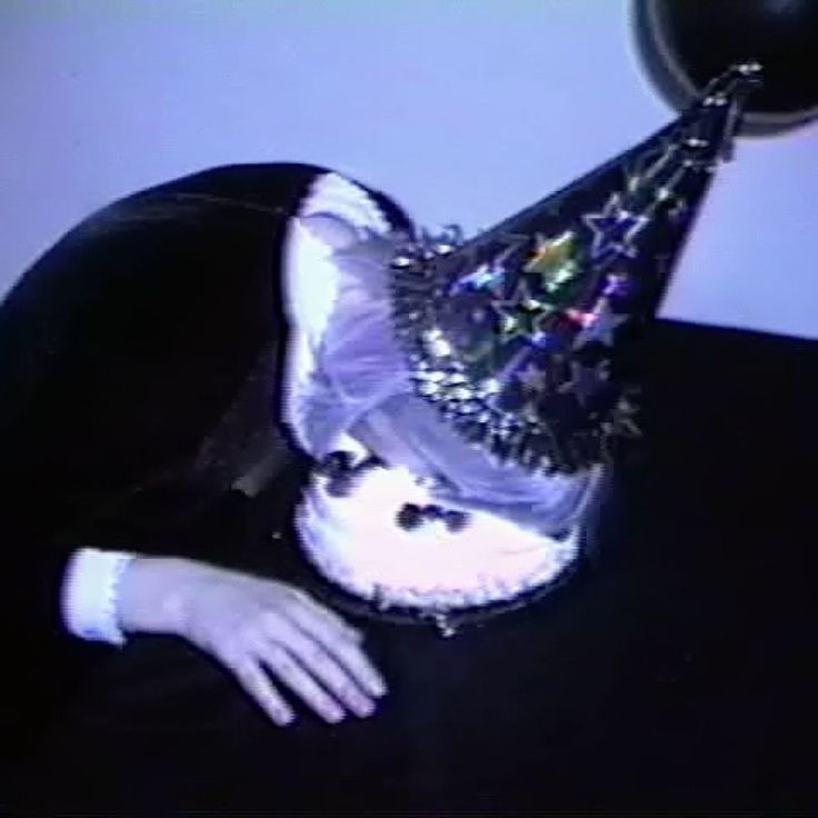 a cat wearing a party hat on top of it's head with its eyes closed