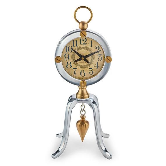 an antique style clock with a bell and pendulum on it's side, sitting on a white background