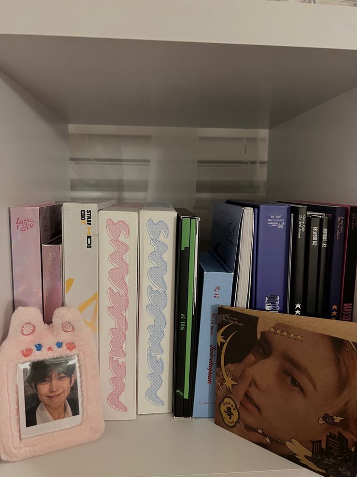 there are many books on the shelf and one has a picture frame in front of it