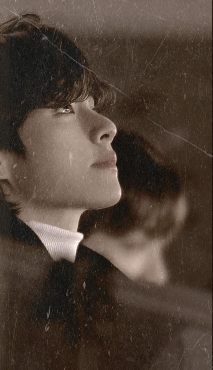 a boy in a suit and tie looking out the window