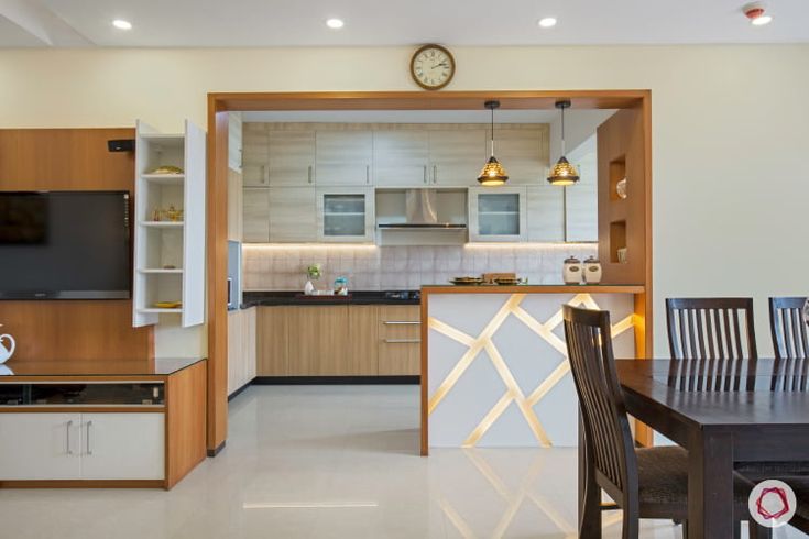 an open kitchen and dining room with a clock on the wall