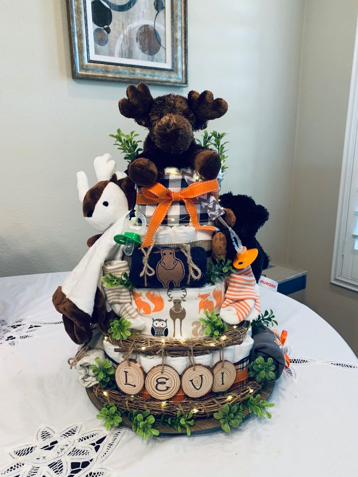 a baby shower cake made with teddy bears and diapers on a table in front of a framed picture