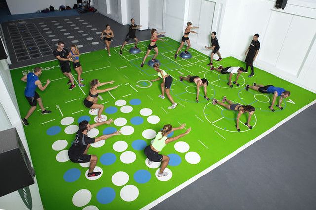 a group of people standing on top of a green floor next to a soccer field