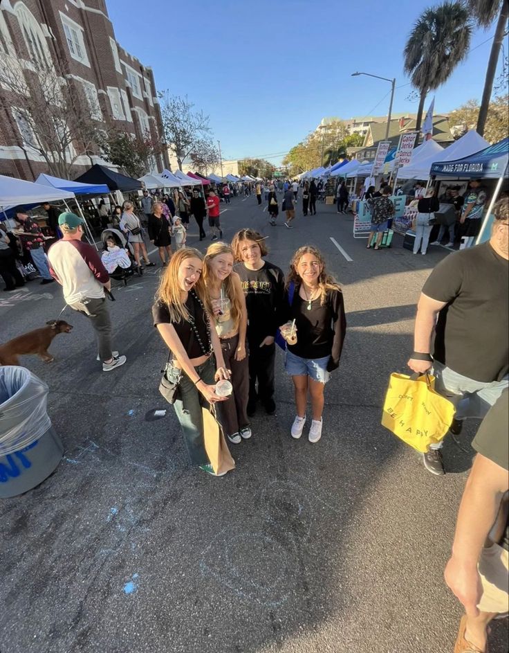 four women standing in the middle of a street