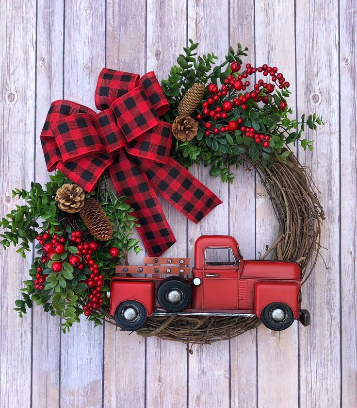 a wreath with a red truck and pine cones