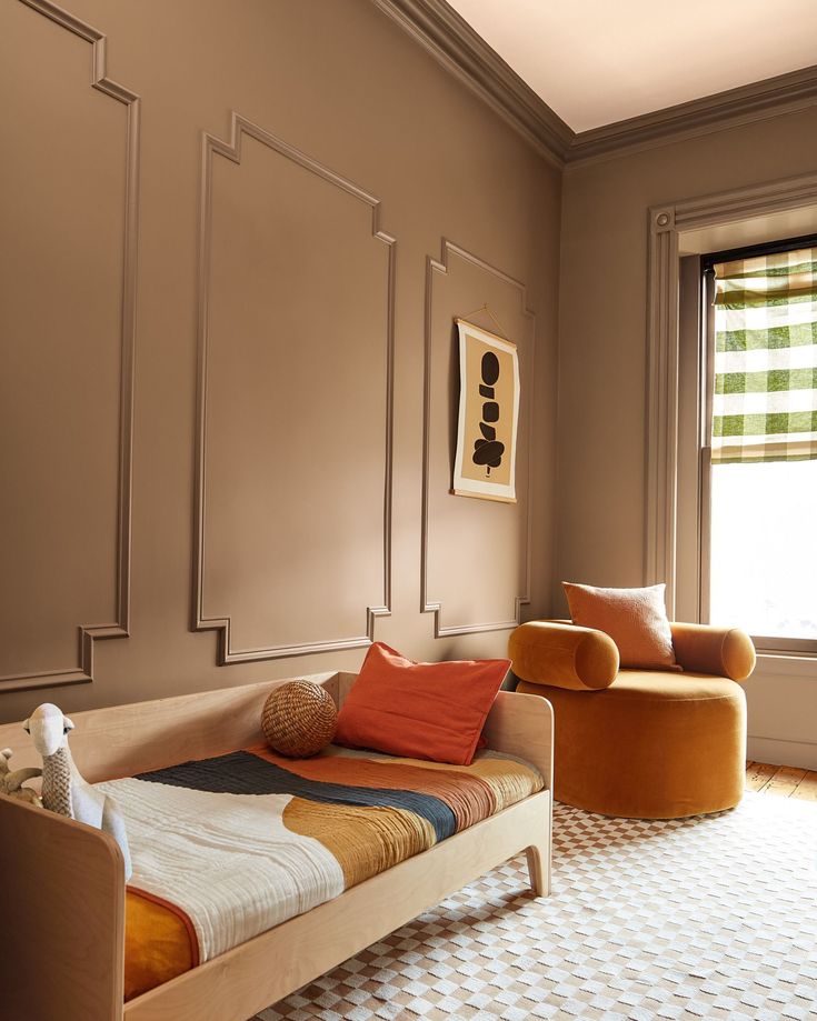 a bed sitting in the middle of a living room next to a chair and window