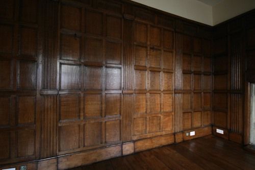 an empty room with wood paneled walls and wooden flooring on the side wall