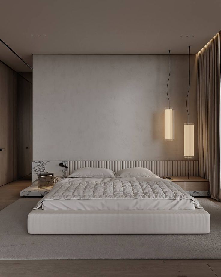 a large white bed sitting in a bedroom next to a wall mounted light above it