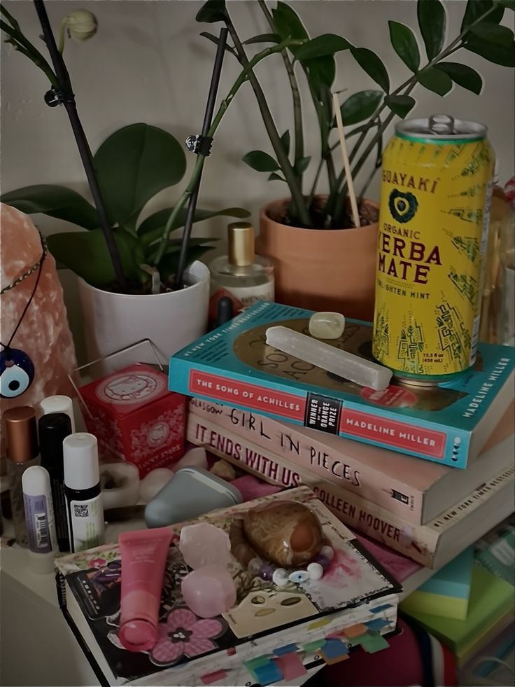 a table topped with lots of books next to plants and other things on top of it