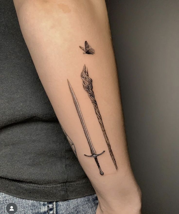 a woman with a tattoo on her arm holding a knife and bow in one hand