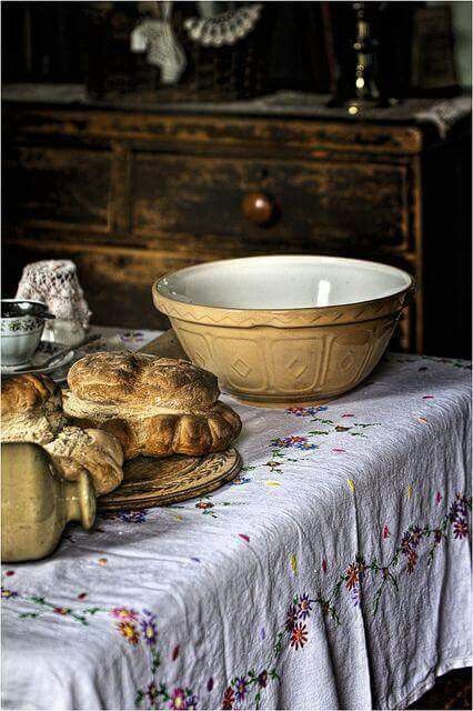 a table topped with bread next to a bowl